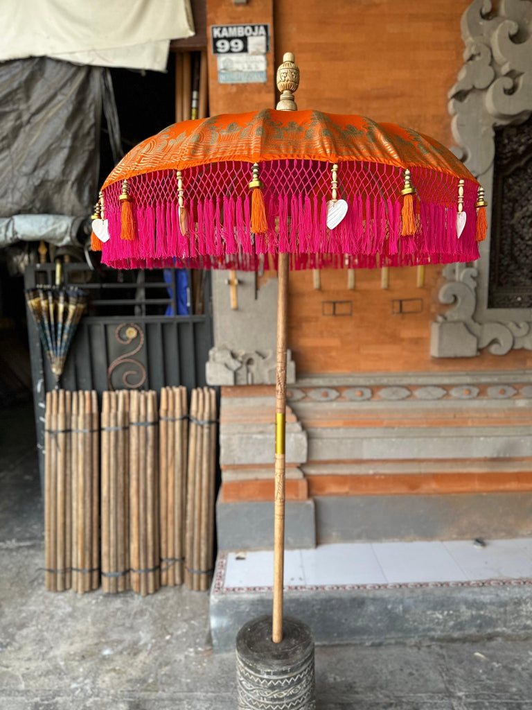 Detailed shot of the hand-carved durian wood pole with brass accents supporting the Clementine Parasol.
