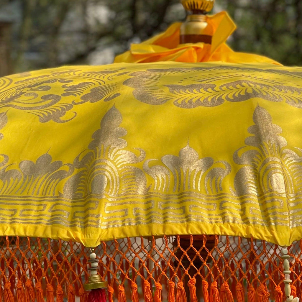 Detailed gold artwork on the Arabella Parasol, showcasing intricate craftsmanship on yellow fabric.