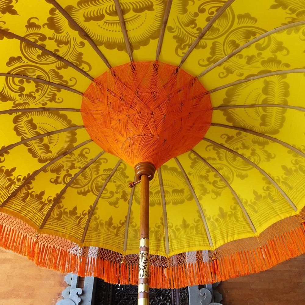 View from below the Arabella Parasol, highlighting orange threading, bamboo spokes, and decorative fringe.