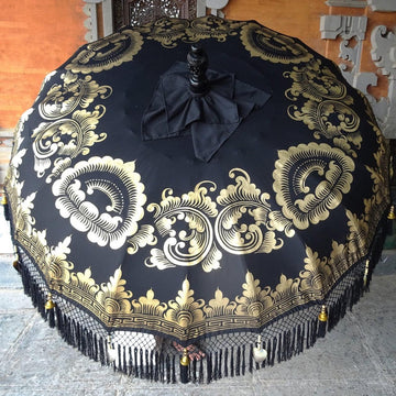 Carl Parasol with bold black canvas and intricate gold ink designs, perfect for luxurious outdoor spaces.