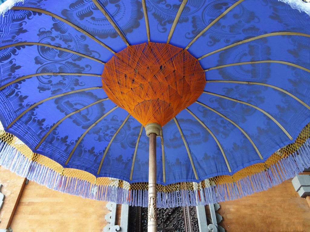 Underside of the Charlotte Parasol showcasing handwoven orange threading and sturdy bamboo spokes for lasting durability.