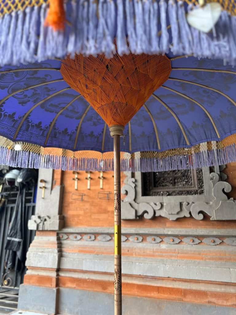 Underside of the Charlotte Parasol showcasing handwoven orange threading and sturdy bamboo spokes for lasting durability.