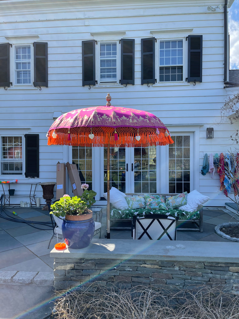 Cecilia Parasol with pink and purple canvas adorned with gold hand-painted designs and bright orange fringe.